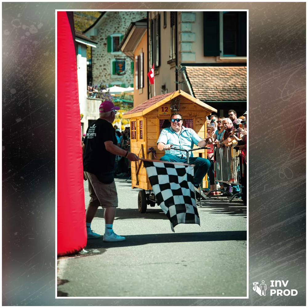 Drapeau à damier agité devant un tracasset en forme de chalet en bois